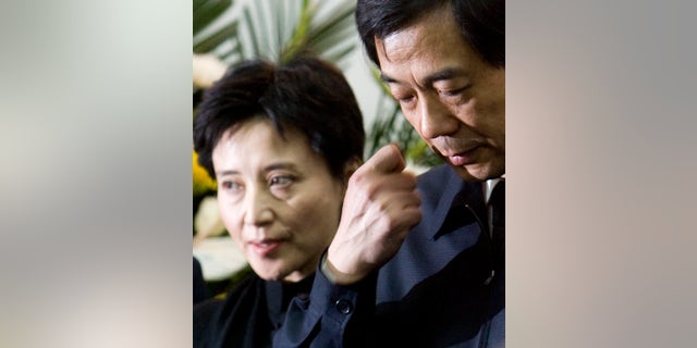 FILE - In this Jan. 17, 2007 file photo, Bo Xilai, right, then China's Minister of Commerce, and his wife Gu Kailai, left, attend a memorial ceremony for Bo's father Bo Yibo, a late revolutionary leader considered one of communist China's founding fathers, at a military hospital in Beijing. Gu could go on trial in the coming days, after being formally charged with the murder of a British businessman who was a close associate of the Bo family. The murder is at the center of a messy political scandal that has highlighted divisions in the Chinese leadership ahead of a once-a-decade political transition in 2012. (AP Photo/Alexander F. Yuan, File)