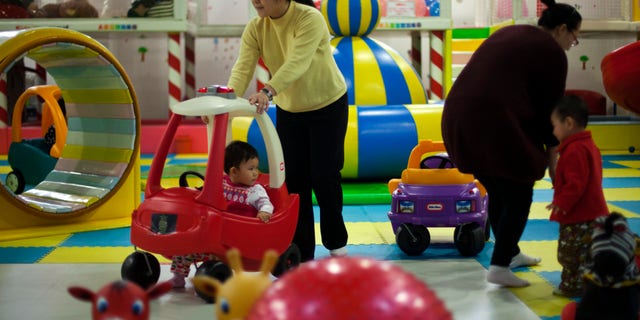 Jan. 10, 2013 - FILE photo of parents playing with their children at a shopping mall in Beijing. China will loosen its decades-old one-child policy and abolish a much-criticized labor camp system, its ruling Communist Party said. Friday,
