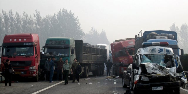 Oct. 7, 2011: People look at the damaged vehicles piled up on a highway road in Huaibei in central China's Anhui province. Three major road accidents in China killed at least 56 people on the last day of a weeklong holiday, including 35 people who died after a bus collided with a car on a northern expressway, state media reported Saturday.