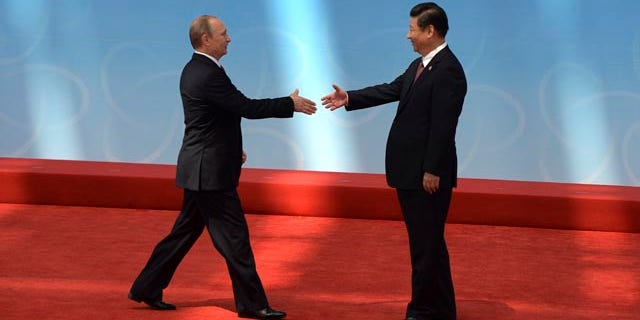 May 21, 2014: Russian President Vladimir Putin, left, is greeted by Chinese President Xi Jinping before the opening ceremony at the fourth Conference on Interaction and Confidence Building Measures in Asia (CICA) summit, in Shanghai. (AP Photo/Mark Ralston, Pool)