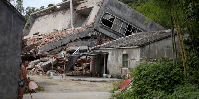 July 16, 2014: A man stands near the razed remains of a Catholic church in a village in Pingyang county of Wenzhou in eastern China's Zhejiang province. Across Zhejiang province, which hugs Chinas rocky southeastern coast, authorities have toppled, or threatened to topple, crosses at more than 130 churches. (AP Photo/Didi Tang)