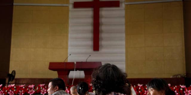 In this photo taken July 16, 2014, members of Yayu Christian Church gather in a hall during their turns to protect the rooftop cross from being demolished at the church in Yaxia village, Pingyang county in Wenzhou in eastern China's Zhejiang province. Across Zhejiang province, which hugs China’s rocky southeastern coast, authorities have toppled, or threatened to topple, crosses at more than 130 churches. (AP Photo/Didi Tang)