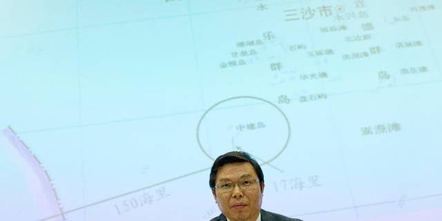 May 8, 2014: Yi Xianliang, deputy director-general of Chinese Ministry of Foreign Affairs' Department of Boundary and Ocean Affairs, stands up, in front of a map showing a disputed zone in South China Sea, to leave a press conference in Beijing, China.