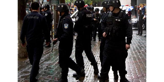 May 22, 2014: Armed policemen prepare to patrol near the site of an explosion in Urumqi, northwest China's Xinjiang Uygur Autonomous Region. (AP Photo/Andy Wong)