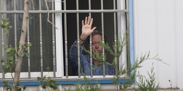 May 24, 2013: American Chip Starnes, co-owner of Specialty Medical Supplies waves from a window after he held hostage by workers inside the Specialty Medical Supplies plant at the Jinyurui Science and Technology Park in Qiao Zi township of Huairou District, on the outskirts of Beijing.