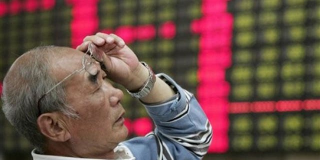 June 4, 2012: An investor looks at the stock price monitor at a private securities company in Shanghai, China.