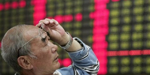 June 4, 2012: An investor looks at the stock price monitor at a private securities company in Shanghai, China.