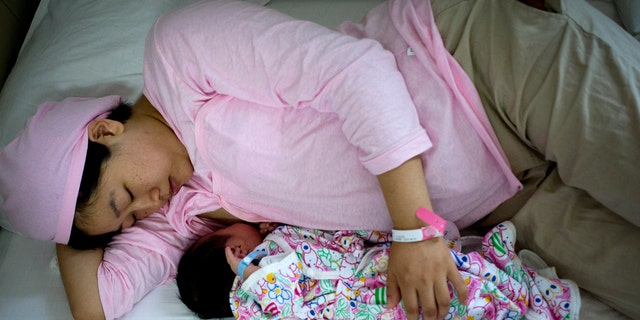 New mother Qi Wenjuan breastfeeds her 1-day-old son at Tiantan Hospital's maternity ward in Beijing, China. (AP Photo/Andy Wong)