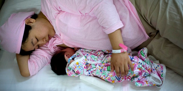 New mother Qi Wenjuan breastfeeds her 1-day-old son at Tiantan Hospital's maternity ward in Beijing, China. (AP Photo/Andy Wong)
