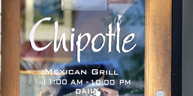 A customer leaves a Chipotle restaurant with food in Portland, Ore., Wednesday, Nov. 11, 2015. Chipotle started reopening its restaurants in the Pacific Northwest on Wednesday after an E. coli outbreak sickened about 45 people, a high-profile example of foodborne illnesses that are more common than the public realizes, health experts say. Forty-three outposts of the Mexican food chain in Washington state and the Portland, Oregon, area were closed at the end of October because of the outbreak that hospitalized more than a dozen people. The first restaurants opened for lunch Wednesday. (AP Photo/Don Ryan)
