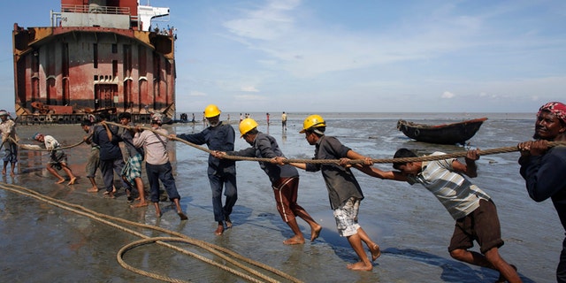 Workers haul a ship to shore for salvage at a ship-breaking yard in Chittagong, Bangladesh.
