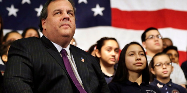 FILE - In this Jan. 7, 2014 file photo, New Jersey Gov. Chris Christie sits with students during a gathering at Colin Powell elementary school in heavily Hispanic Union City, N.J. after he ceremonially signed a bill that lowers tuition costs at public colleges for New Jersey students who lack lawful immigration status. A day after revelations that Christie's administration may have closed highway lanes to exact political retribution, the prospective Republican presidential candidate is faced with what may be the biggest test in his political career. (AP Photo/Mel Evans, File)