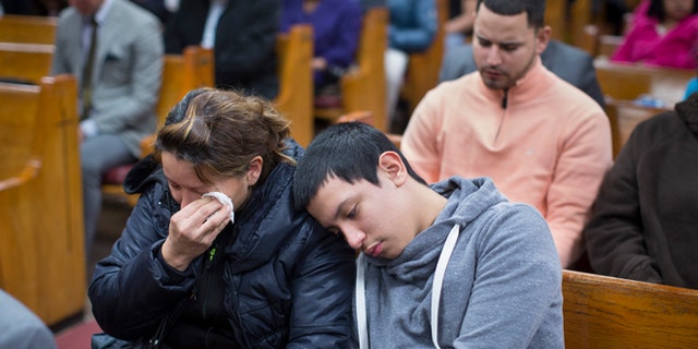 Parishioners mourn during Sunday services at the Church of God of Third Avenue as the congregation welcomed members of the Spanish Christian Church that was destroyed by Wednesday's explosion in the East Harlem neighborhood of New York, Sunday, March 16, 2014. The Spanish Christian Church had been located on the first floor of one of the destroyed buildings. On Saturday a crew at the blast site found a large Bible in the rubble and returned it to the church's pastor. (AP Photo/John Minchillo)