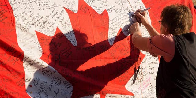 People continue to visit and build upon the memorial to Cpl Nathan Cirillo that has been growing outside of The Lieutenant-Colonel John Weir Foote Armoury in Hamilton, Ontario on Friday, Oct. 24, 2014. Cirillo, a reserve soldier with the Argyll and Sutherland Highlanders, was killed by an armed gunman on Parliament Hill early on Wednesday morning. (AP Photo/The Canadian Press, Peter Power)