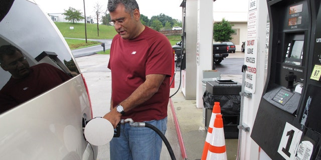 Samir Cook fills up his vehicle at a city-run station on Saturday, July 19, 2014, in Somerset, Ky. The station on the outskirts of Somerset opened to the public on Saturday, selling regular unleaded gas for $3.36 a gallon. In the first three hours, about 75 customers fueled up at the no-frills city station, where there are no snacks, no repairs and only regular unleaded gas. The citys mayor says he hopes the no-frills station will lower gas prices around town. (AP Photo/Bruce Schreiner)