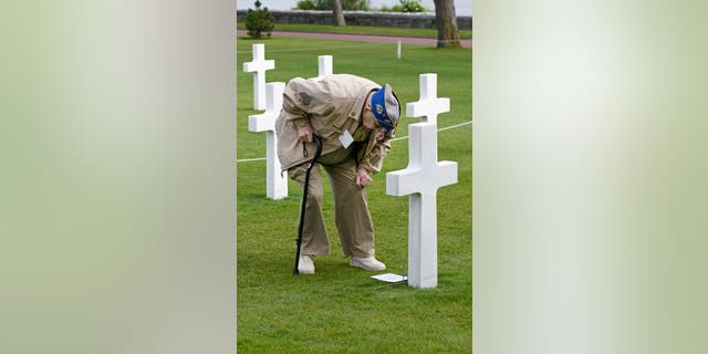 U.S. WW II veteran pays respects to a fallen comrade in Normandy, France. President Biden was accused of disrespecting the anniversary of D-Day for his late tweet commemorating the historical day. (AP Photo/Remy de la Mauviniere)