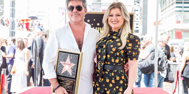 Simon Cowell and Kelly Clarkson attend a ceremony honoring Cowell with a star on the Hollywood Walk of Fame on August 22, 2018.
