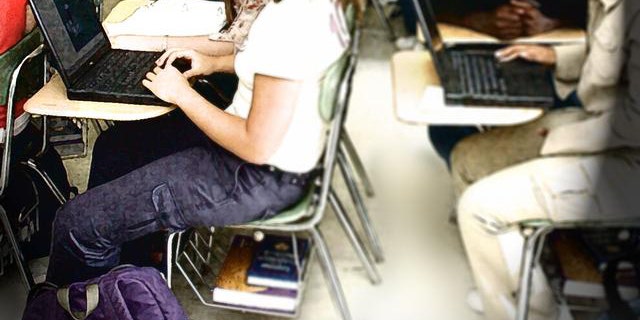 Sophomores in Jennifer Litzen's world literature class at Northern Durham High School use laptops from the school's mobile computer lab for a class project Wednesday, Aug. 20, 2003, in Durham, N.C. The school has a wireless mobile computer lab which brings laptops to classrooms so students can learn to use multi-media applications and use the internet. (AP Photo/Jeffrey A. Camarati)