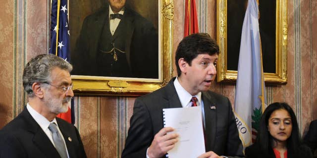 FILE - U.S. Attorney Steven Dettelbach holds up the settlement agreement with the City of Cleveland as he speaks at a news conference May 26, 2015, in Cleveland.