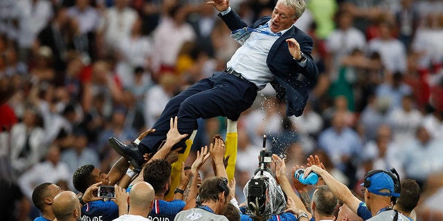 France's head coach Didier Deschamps thrown into the air by his players as they celebrated.