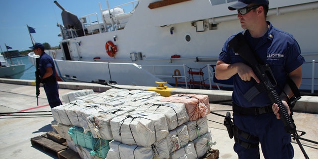 Under heavy security a pile of packages filled with cocaine is piled up after being off loaded from the Coast Guard Cutter Bernard C. Webber after it was seized during Operation Martillo, worth an estimated $27 million on April 26, 2013 in Miami, Florida. (Photo by Joe Raedle/Getty Images)