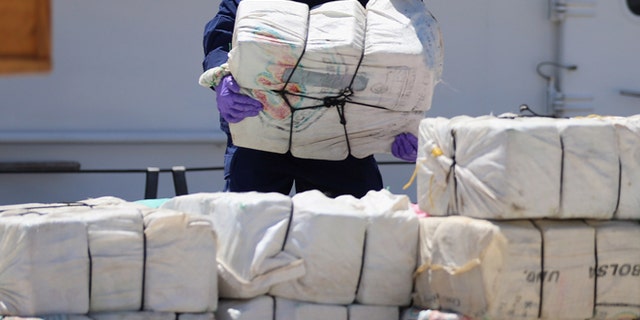 MIAMI, FL - APRIL 26: A crew member from the Coast Guard Cutter Bernard C. Webber piles up some of the 2,200 pounds of cocaine after it was seized during Operation Martillo, worth an estimated $27 million on April 26, 2013 in Miami, Florida. The cocaine was found while the crew was conducting a law enforcement patrol, where they located a 68-foot fishing vessel in the western Caribbean Sea, April 18, 2013. The crew of the Cutter Gallatin boarded the vessel, located 2,200 pounds of cocaine, and detained three suspected smugglers. (Photo by Joe Raedle/Getty Images)