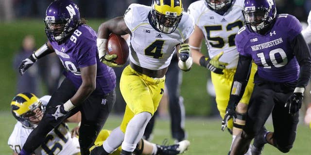 In this Nov. 8, 2014 file photo Michigan running back De'Veon Smith (4) runs against Northwestern during an NCAA college football game in Evanston, Ill. A Republican lawmaker in Michigan introduced a bill Dec. 2, 2014 to block collective bargaining for athletes that is on the fast track through this lame-duck legislative session, though there are no reports of such efforts at any of Michigan's public or private universities and opponents say it's a non-issue in their state. Athletes at Northwestern, a private school, voted in April to form the nation's first union for student athletes, a case the National Labor Relations Board has not yet ruled on. (AP Photo/Nam Y. Huh, File)