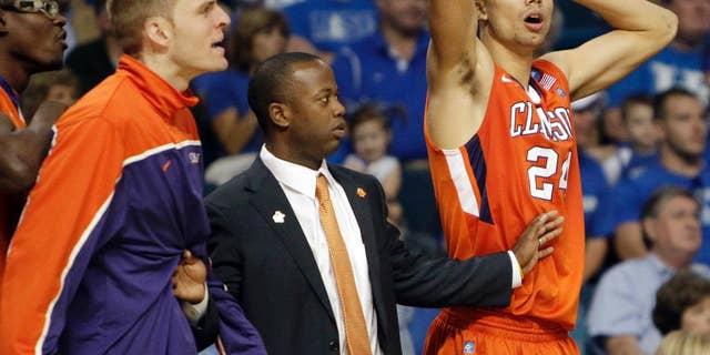FILE - In this March 17, 2014, file photo, Clemson players Jonah Baize, left, Milton Jennings (24) and assistant coach Earl Grant, center, react to a call by an official that went against them during the second half of an East Regional second round NCAA tournament college basketball game against West Virginia in Tampa, Fla. Grant, now coach of the College of Charleston, knows he needs to get his team thinking about basketball and forgetting a summer in which coach Doug Wojcik was fired amid allegations of verbal abuse. (AP Photo/John Raoux, File)