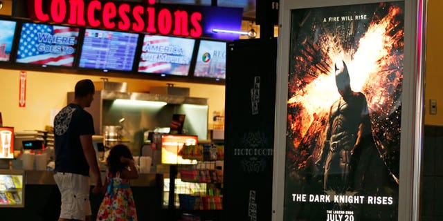 FILE - In this July 20, 2012 file photo, people walk past a "The Dark Knight Rises," at Regal Cinemas at Crossgates Mall in Albany, N.Y.