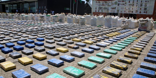 This photo released by Colombia's National Police shows packages of cocaine on display in Necocli, in the northwestern state of Antioquia, Colombia, Sunday, May 15, 2016. The National Police agency said commandos backed by helicopters seized about eight tons of cocaine on a banana plantation belonging to a gang known as the Clan Usuaga and was apparently destined for the Caribbean and then to the United States. Authorities say its the biggest cocaine seizure in Colombia's history. (Colombia National Police via AP)