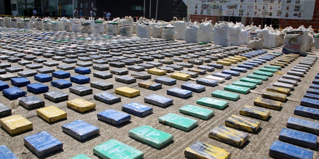 This photo released by Colombia's National Police shows packages of cocaine on display in Necocli, in the northwestern state of Antioquia, Colombia, Sunday, May 15, 2016. The National Police agency said commandos backed by helicopters seized about eight tons of cocaine on a banana plantation belonging to a gang known as the Clan Usuaga and was apparently destined for the Caribbean and then to the United States. Authorities say its the biggest cocaine seizure in Colombia's history. (Colombia National Police via AP)