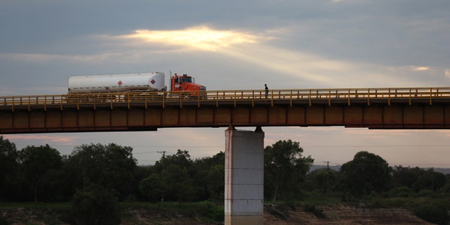 In this Feb. 13, 2015 photo, a truck loaded with crude from the Campo Rubiales oil field crosses the bridge over the Manacacias River in Puerto Gaitan, Colombia. A net oil importer not too long ago, Colombia is now the fifth biggest supplier to the U.S. (AP Photo/Fernando Vergara)