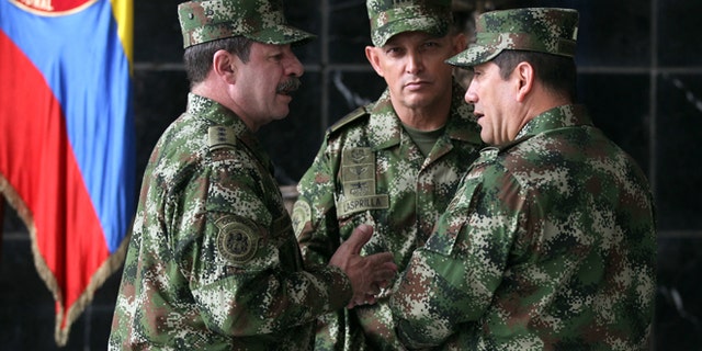 FILE - In this Feb. 18, 2014, file photo, the new Colombian armed forces commander Gen. Juan Pablo Rodríguez, right, talks to newly appointed chief of staff Gen. Javier Florez, left, and army commander Gen. Jaime Lasprilla, center, after a press conference where Defense Minister Juan Carlos Pinzon announced the firing of the fromer armed forces chief Gen. Leonardo Barrero in Bogotá, Colombia. Gen. Rodríguez and Gen. Lasprilla are among dozens of senior Colombian army officers implicated in the killing of 3,000 civilians falsely claimed to be rebels a decade ago have risen through the ranks and are escaping punishment for their roles in one of the worst atrocities committed in Latin America, Human Rights Watch said Wednesday, June 23, 2015. (AP Photo/Fernando Vergara, File)