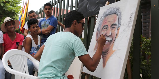 Melquin Merchan paints a portrait of 'Gabo' in front of the house where he was born in Aracataca, Colombia.