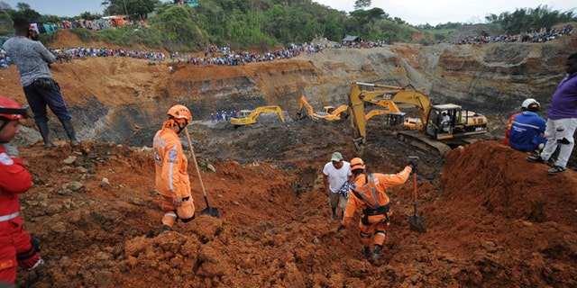 People watch for the search of survivors at a collapsed illegal gold mine in Santander de Quilichao, southern Colombia, Thursday, May 1, 2014. Colombian rescuers on Thursday hunted for more than a dozen people feared trapped beneath debris left by in the collapse of an illegal gold mine that killed at least three people, officials said. (AP Photo/Oswaldo Paez, El Pais)