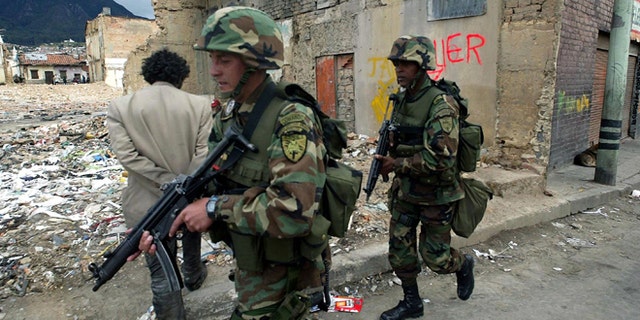 BOGOTA, COL- AUGUST 7: Colombian soldiers patrol the area just blocks from parliament where suspected rebels targeted mortar rounds as Alvaro Uribe was sworn in as president August 7, 2002 in Bogota, Colombia. Reports say at least14 people were killed and 69 wounded. (Photo by Getty Images)