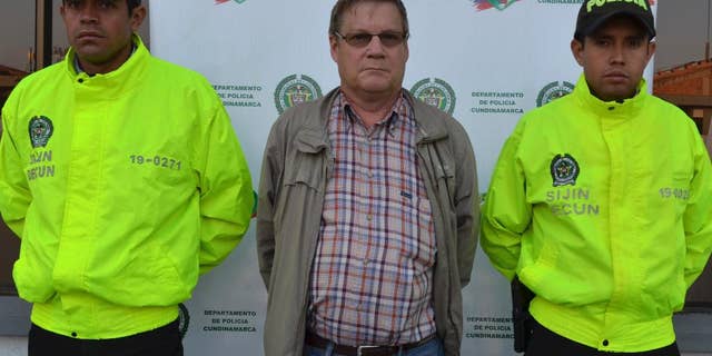 This photo released by Colombia's National Police shows American citizen Martin Stendal flanked by police officers at a police station in Bogota, Colombia, Thursday, Feb. 19, 2015. Police Col. Flavio Meza said that Stendal, a 59-year old native of Minnesota, surrendered Wednesday night to face an arrest warrant charging him with supporting terrorism and collaborating with the Revolutionary Armed Forces of Colombia rebel movement. Stendal says in a video posted online that he had been set up and that his trips into rebel territory to distribute Bibles and radios were only for ministering. (AP Photo/Colombia's National Police)