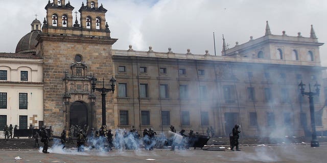 Riot police stand in the capital's main square during clashing with students in downtown Bogota, Colombia, Thursday, Aug. 29, 2013.