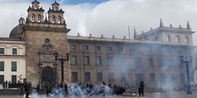 Riot police stand in the capital's main square during clashing with students in downtown Bogota, Colombia, Thursday, Aug. 29, 2013.