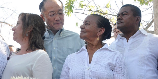 World Bank President Dr. Jim Yong Kim looks at Norma Quiroz, widow of slain community activist Aljemiro Quiroz, in Guacoche, Colombia, Thursday, Jan. 14, 2016.