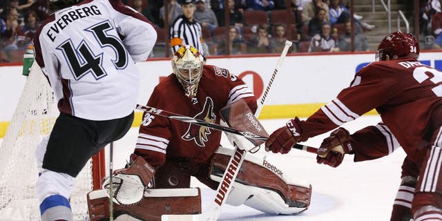 Colorado Avalanche's Dennis Everberg (45), of Sweden, passes the puck past Arizona Coyotes' Louis Domingue (35) as Coyotes' Klas Dahlbeck (34), of Sweden, during the third period of an NHL hockey game Thursday, March 19, 2015, in Glendale, Ariz. The Avalanche defeated the Coyotes 5-2. (AP Photo/Ross D. Franklin)