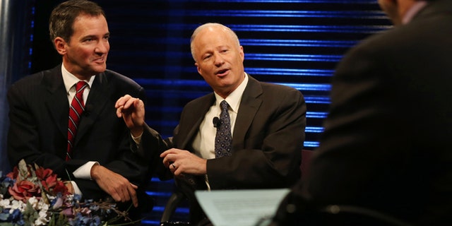Andrew Romanoff, left, gently pushed by Republican incumbent Mike Coffman, who won his race in a diverse district. The RNC is holding Coffman up as a model for how to attract Latino voters. (AP Photo/David Zalubowski)