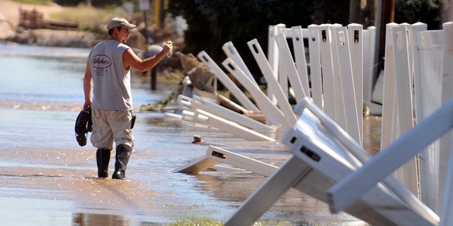 A man wades through the flood waters Sept. 18, 2013 in Evans, Colo. Residents are advised to wash everything that comes in contact with the water. (AP Photo/The Greeley Tribune, Joshua Polson)