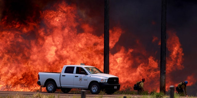 July 7, 2014: Firefighters with the Bureau of Land Managment battle the Colorado Gulch fire as it advances towards homes near Hailey, Idaho. (AP Photo/Times-News, Ashey Smith)
