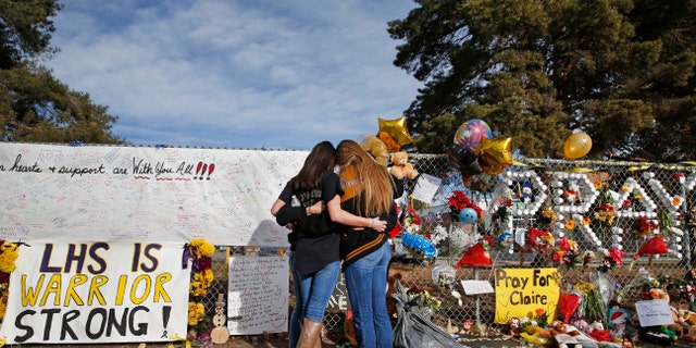 Dec. 19, 2013: In this file photo, Arapahoe High School students hug at a tribute site for fatally-wounded student Claire Davis, who was shot by classmate Karl Pierson during a school attack six days earlier at Arapahoe High School, in Centennial, Colo.