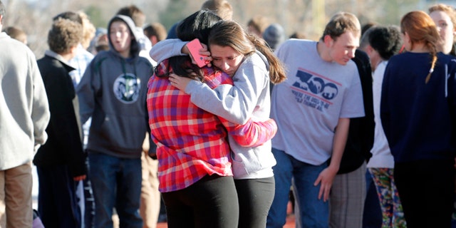 Students comfort each other at Arapahoe High School in Centennial, Colo., on Friday, Dec. 13, 2013, where a student shot at least one other student at a Colorado high school Friday before he apparently killed himself, authorities said. The shooter entered Arapahoe High School in a Denver suburb armed with a shotgun and looking for a teacher he identified by name, said Arapahoe County Sheriff Grayson Robinson. (AP Photo/Ed Andrieski)