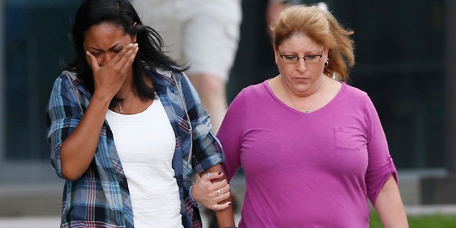Lasamoa Cross, left, wipes tears from her face as she leaves the Arapahoe County Courthouse with Theresa Hoover, the mother of her boyfriend, Alexander J. Boik, who was killed in the theatre massacre Friday, Aug. 7, 2015, in Centennial, Colo. Jurors failed to agree on a death sentence for Colorado theater shooter James Holmes, prompting shocked sobs from victims, police officers and his own mother. (AP Photo/David Zalubowski)