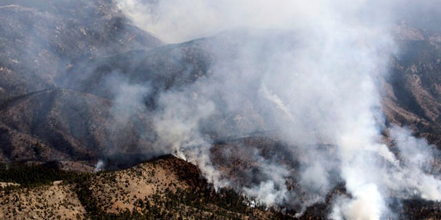 March 27: Smoke rises from the Lower North Fork Wildfire as it burns near the foothills community of Conifer, Colo
