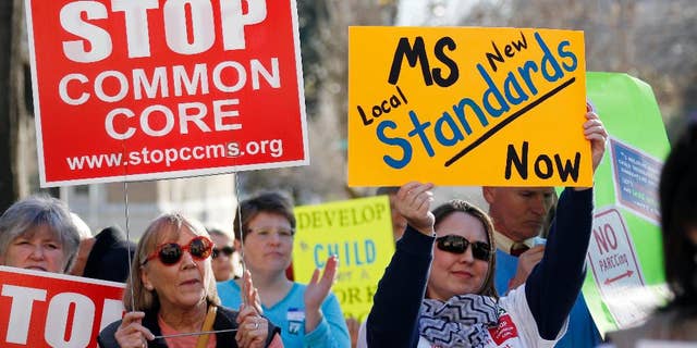 FILE - In this Jan. 6, 2015 file photo, Common Core opponents wave signs and cheer at a rally opposing Mississippi's continued use of the Common Core academic standards on the steps of the Capitol in Jackson, Miss. Results for some of the states that participated in Common Core-aligned testing for the first time this spring are out, with overall scores higher than expected though still below what many parents may be accustomed to seeing. (AP Photo/Rogelio V. Solis,File)