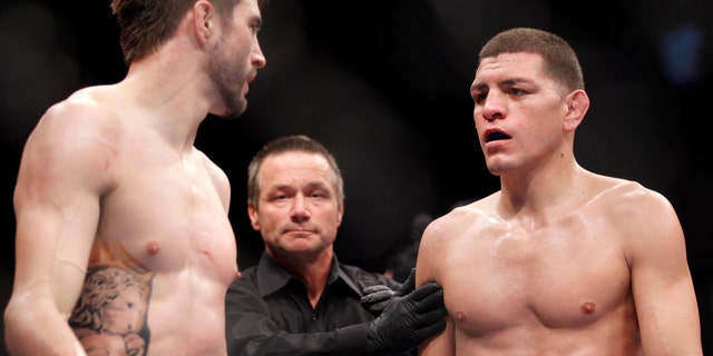 Carlos Condit, left, and Nick Diaz stare each other down as referee Steve Mazzagatti separates them at the end of the third round during their UFC interim welterweight mixed martial arts title match, Saturday, Feb. 4, 2012 at The Mandalay Bay Resort & Casino in Las Vegas. Condit won by unanimous decision. (AP Photo/Eric Jamison)